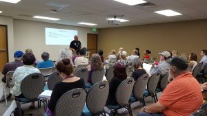 Seniors, caregivers and professionals listen as Colorado Springs Police Det. Charles Szatkowski presents Friday, June 15, for World Elder Abuse Awareness Day at Silver Key Senior Services.