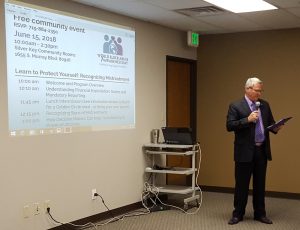 Seniors, caregivers and professionals listen as El Paso County Department of Human Services Deputy Executive Director Chris Garvin speaks Friday, June 15, for World Elder Abuse Awareness Day at Silver Key Senior Services.